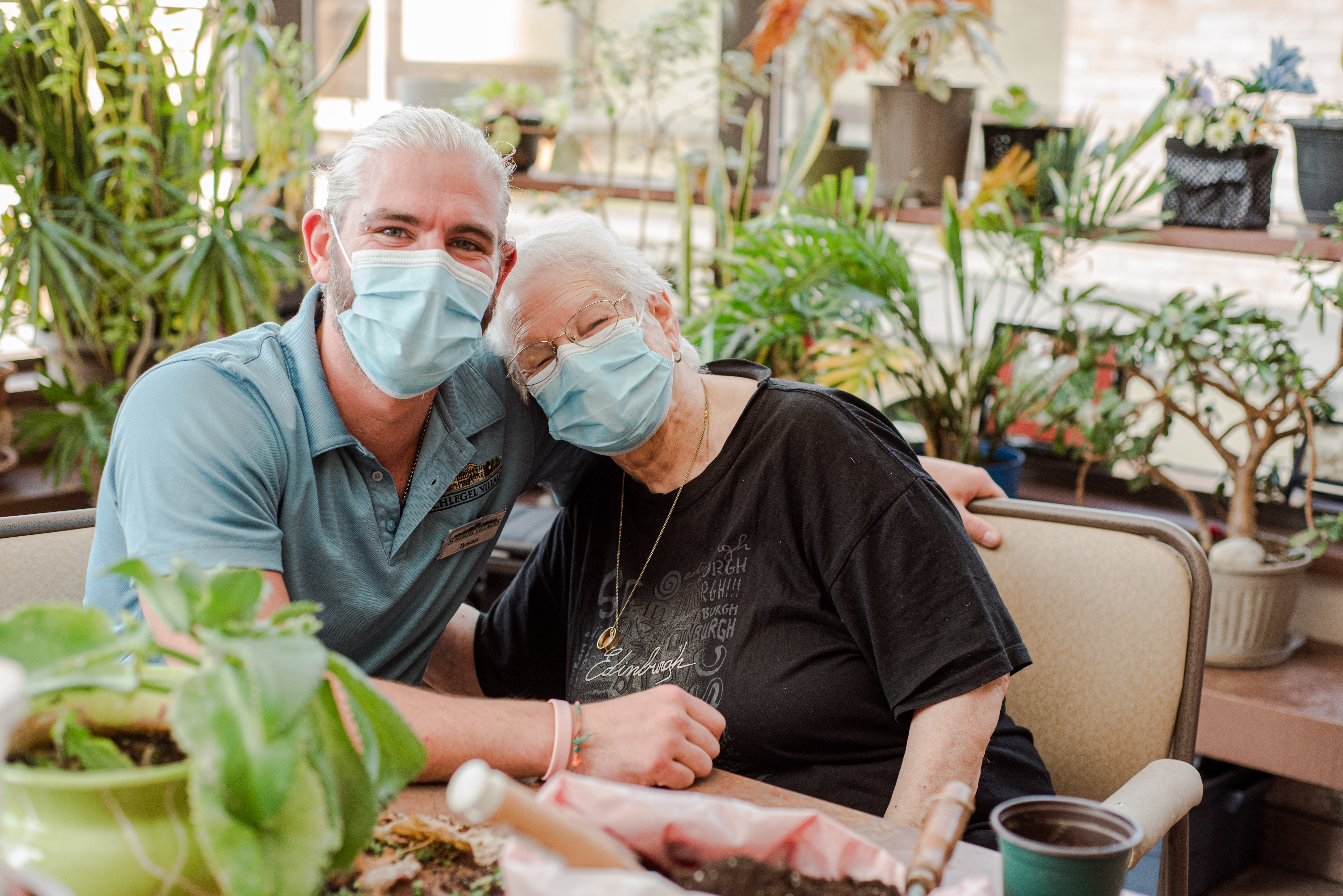 Team Member sits with resident in the greenhouse