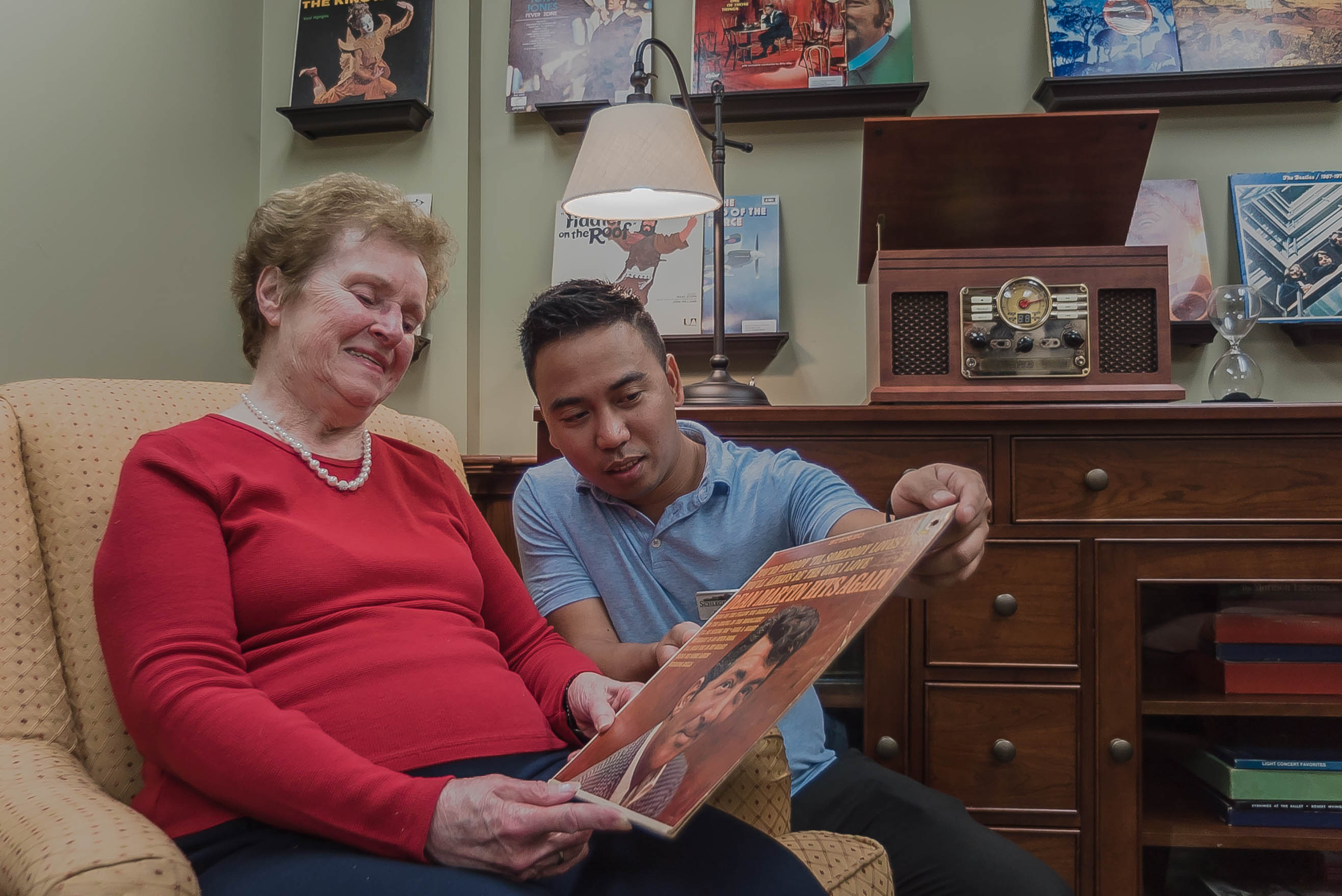 Resident with team member looking a record album cover