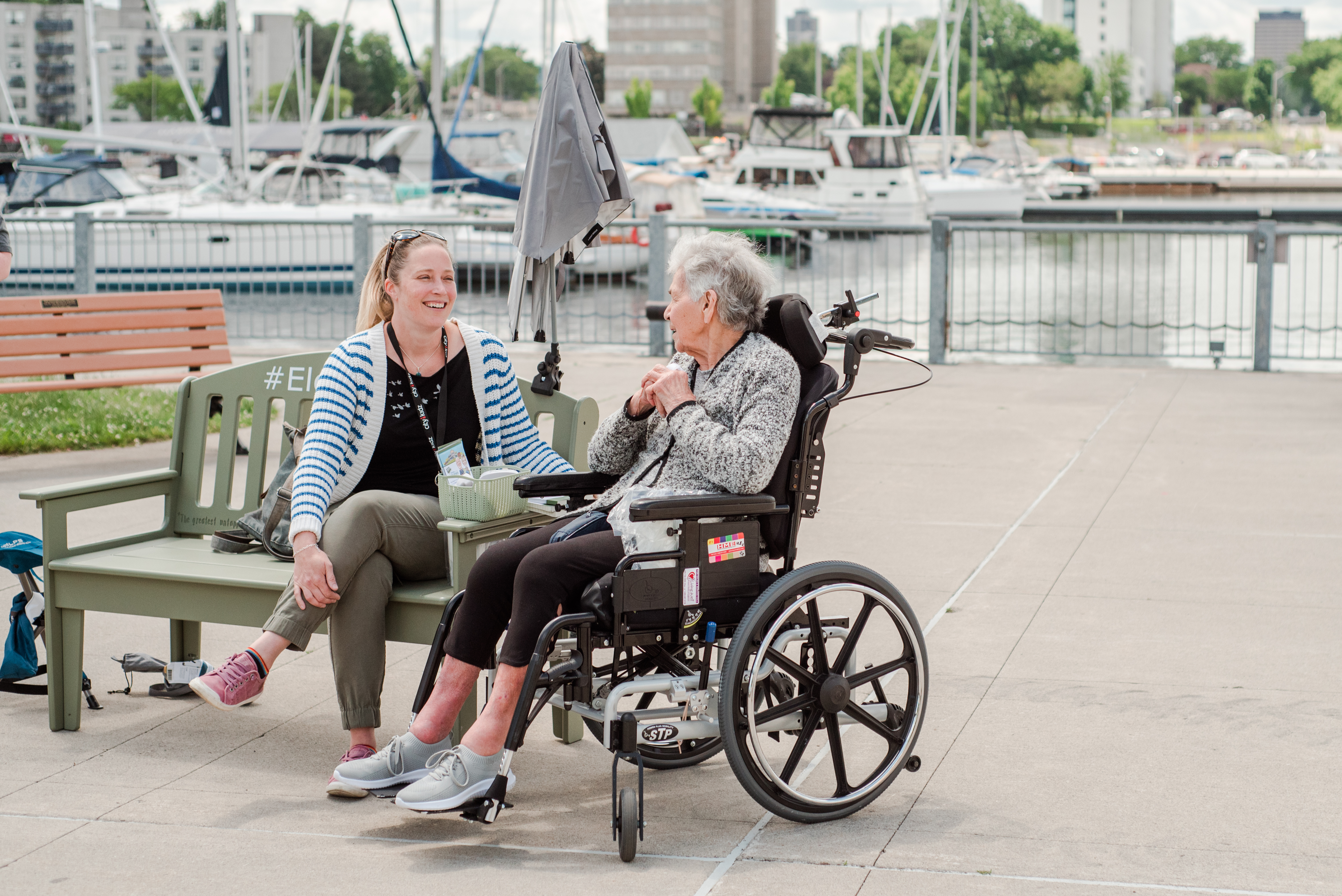 Senior and community member sitting on the green bench