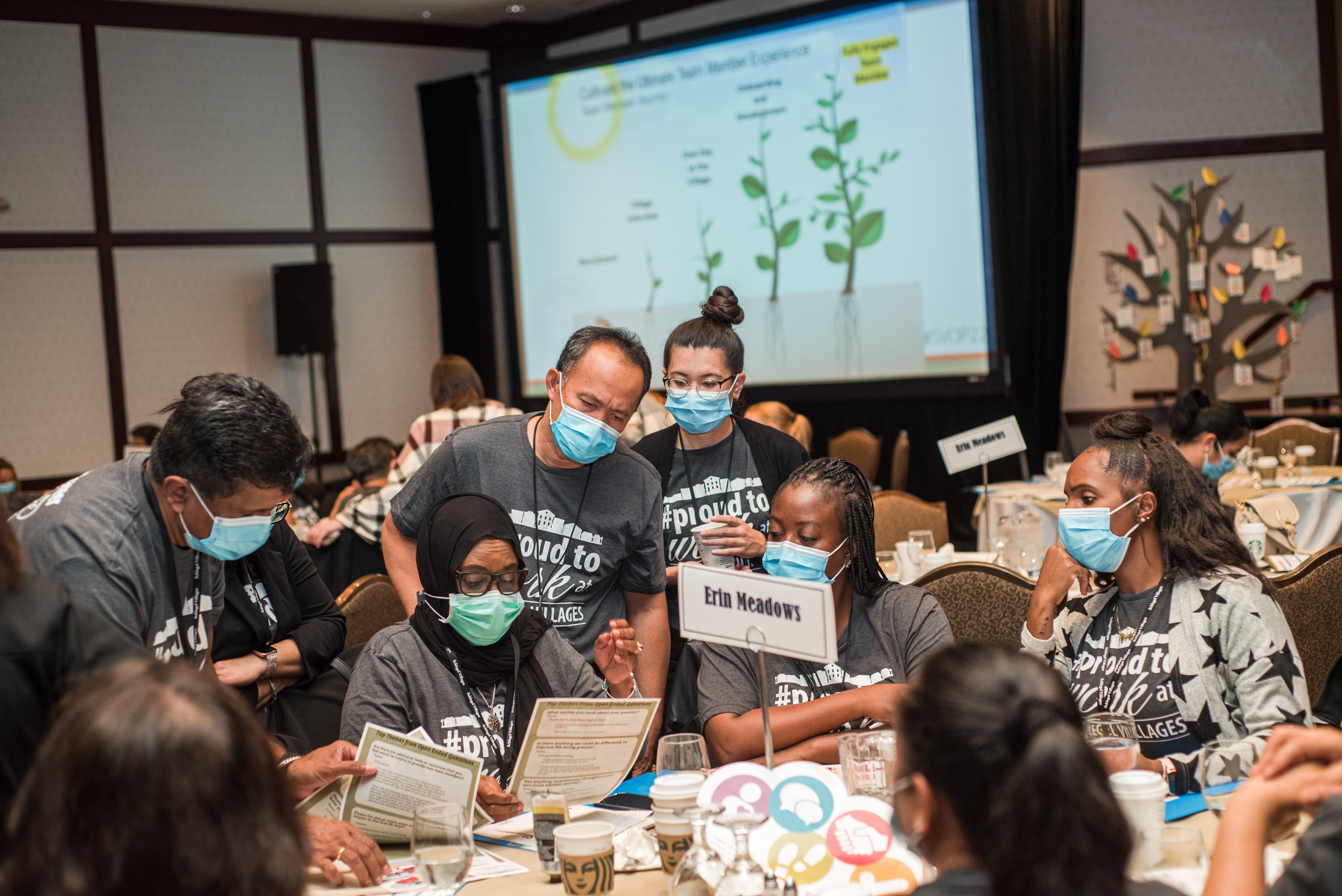 Team members wearing Proud to Work at t-shirts while brainstorming at Operational Planning