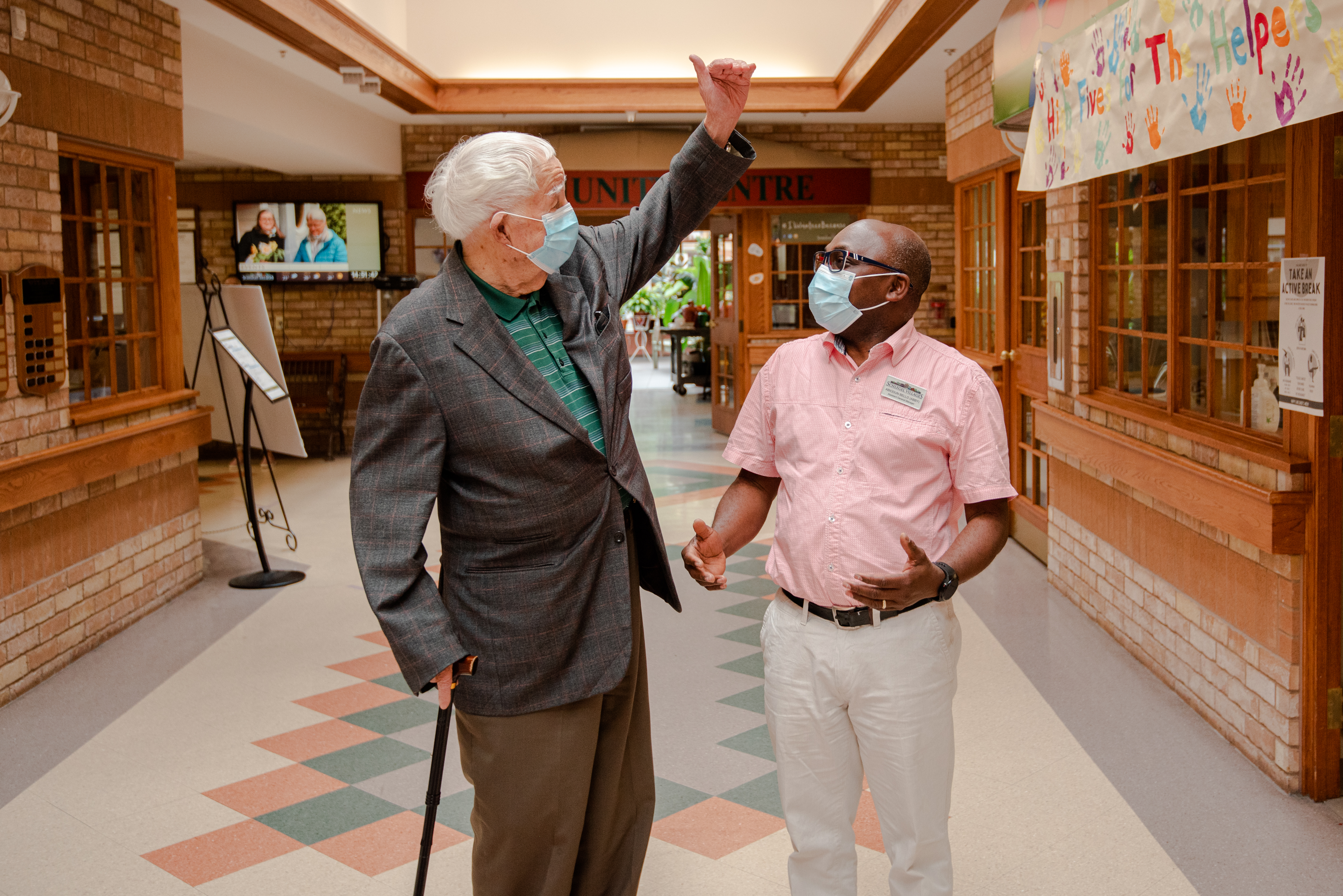 Schlegel Villages team member walks down main street with senior man