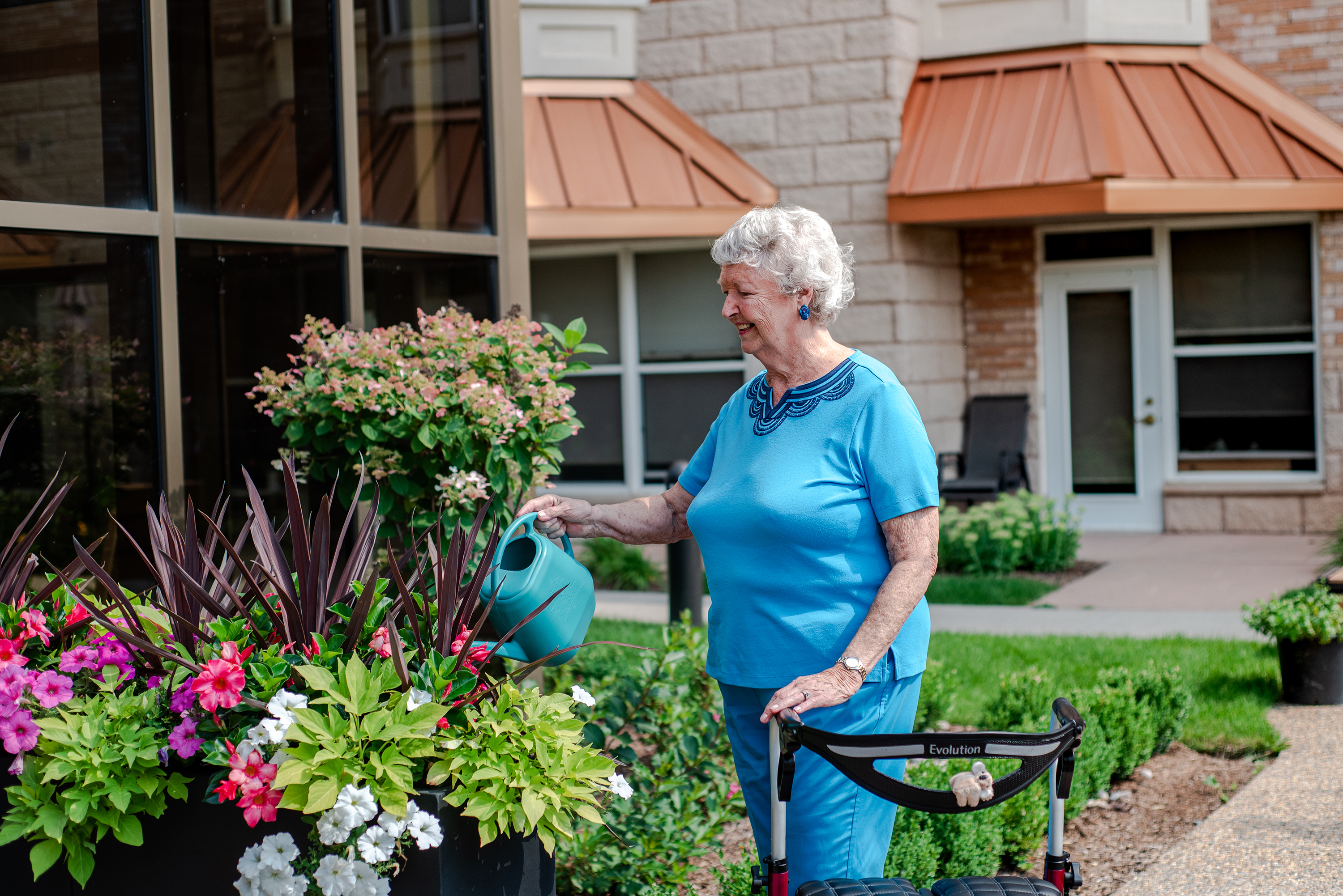 Senior lady watering plants in the courtyard