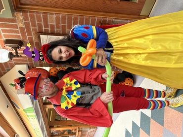 On Halloween, Umme is dressed as a colourful Disney princess alongside another St. Clair team Member dressed as a clown.