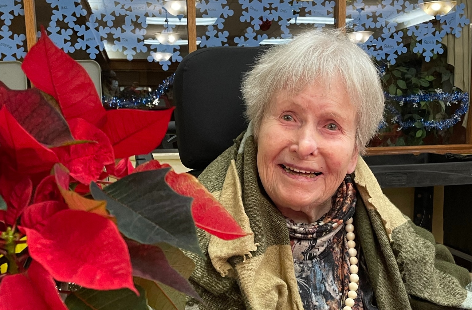 Senior woman smiling with a poinsettia