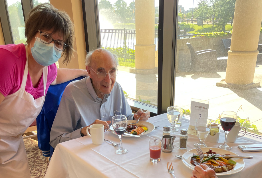 Woman serves senior man a meal in the dining room