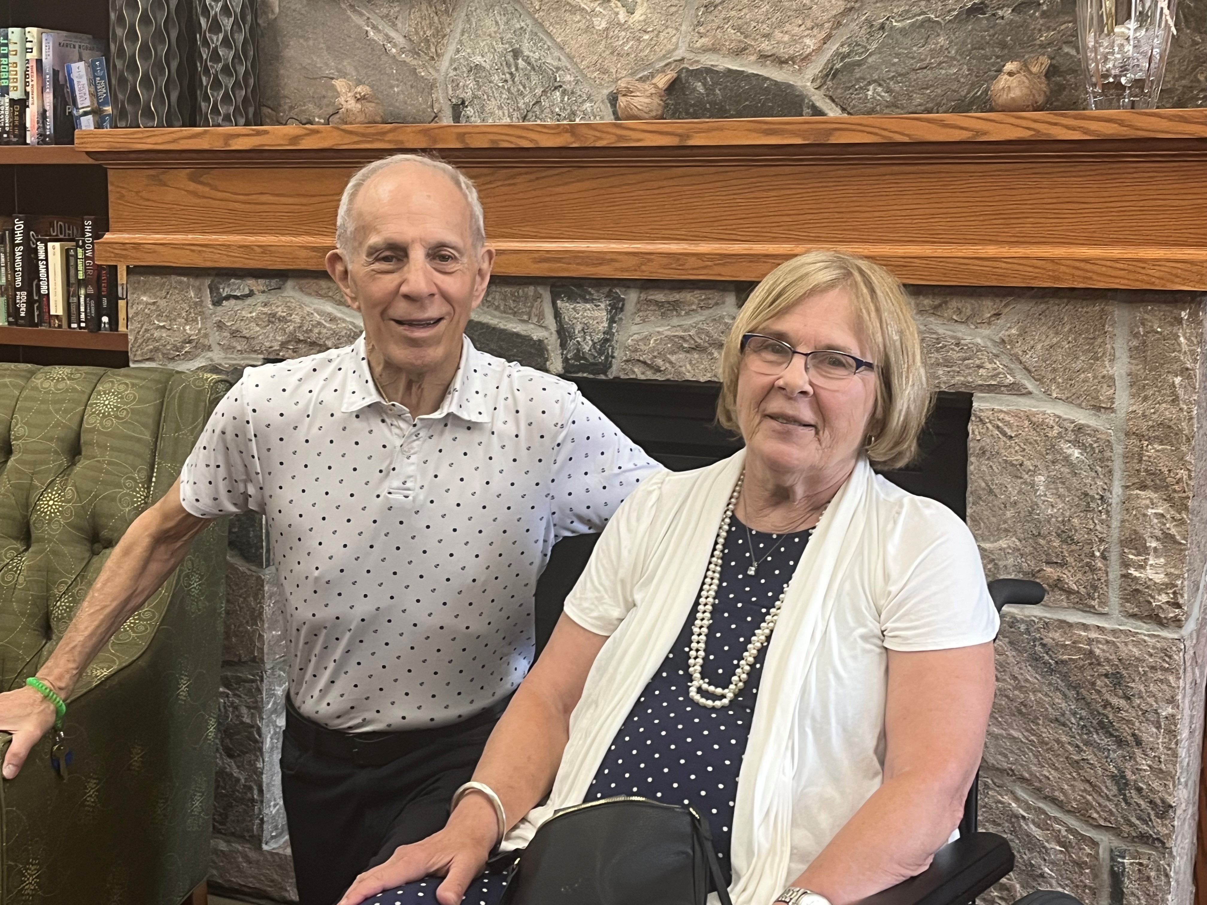 John and Donna pose in front of the fireplace in the Library at The Village of Erin Meadows. 