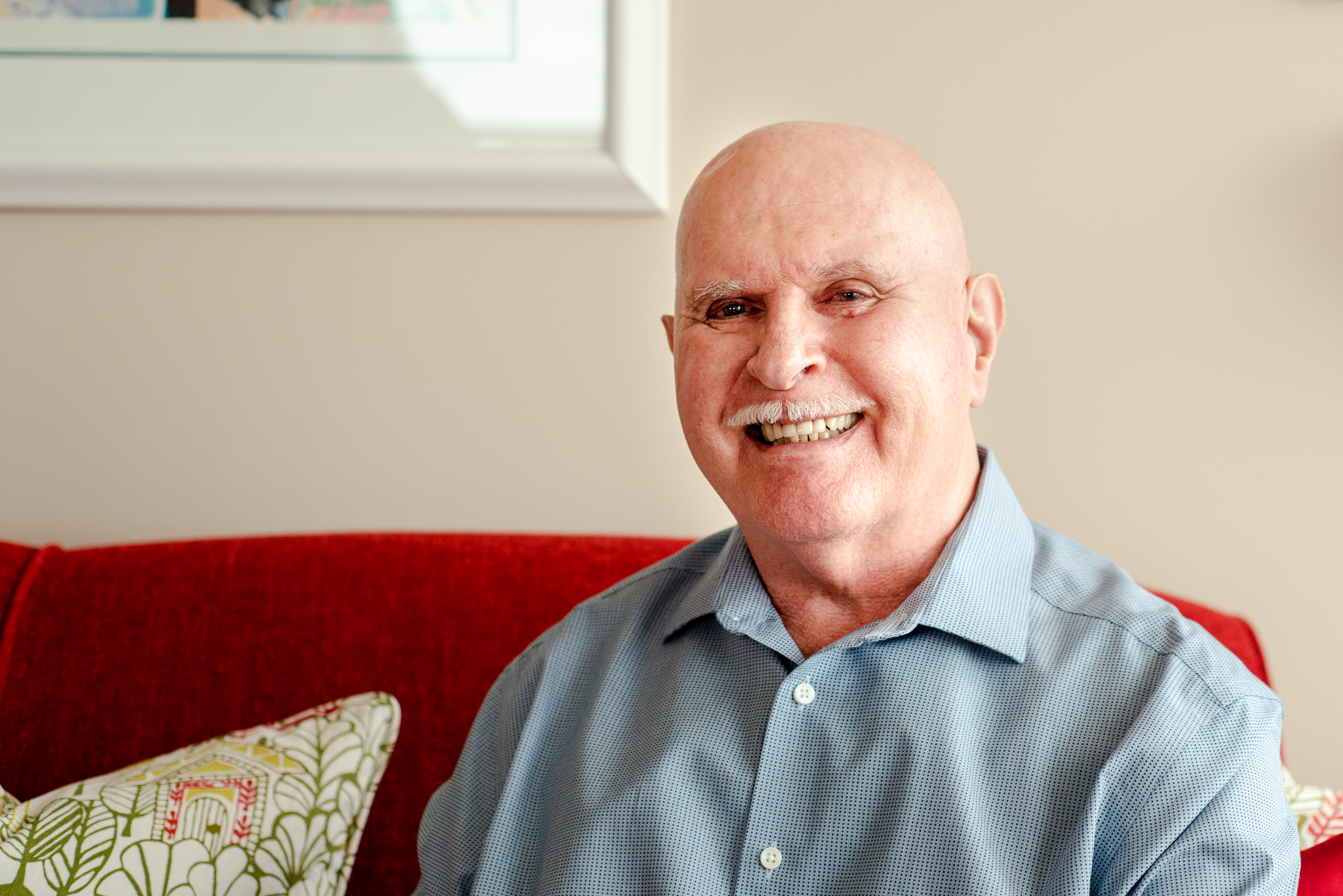 Stuart smiles brightly in a close-up portrait photo. 