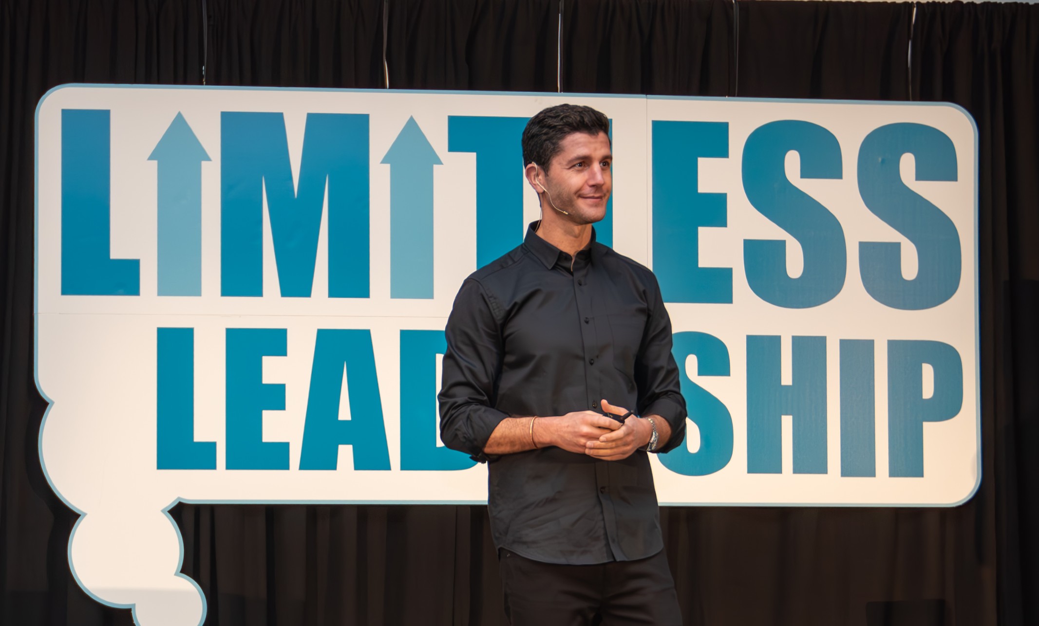 Speaker Ben Nemtin stands before a sign that says Limitless Leadership.