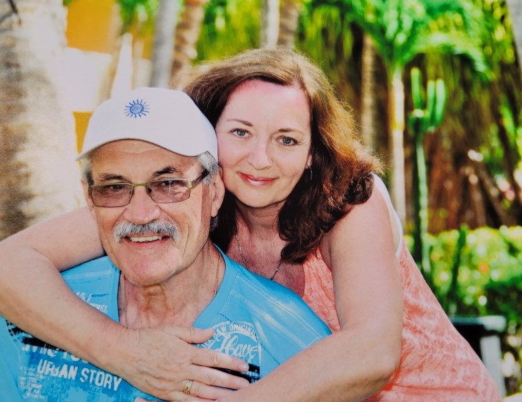 Dave and Evelyn smile for the camera, Evelyn's arms draped over Dave's shoulders, during a trip to The Dominican Republic. 